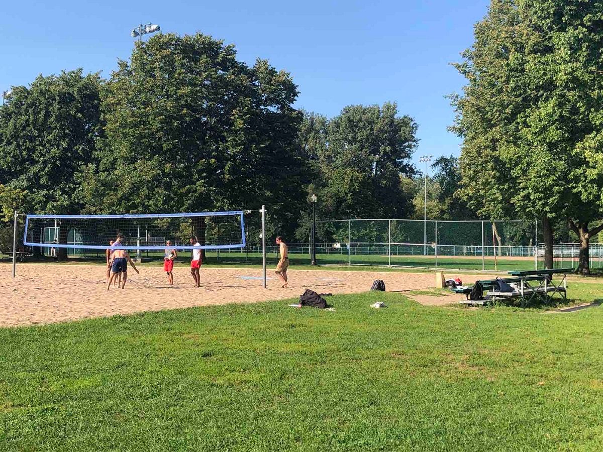 Des personns jouant au beach volley dans un parc