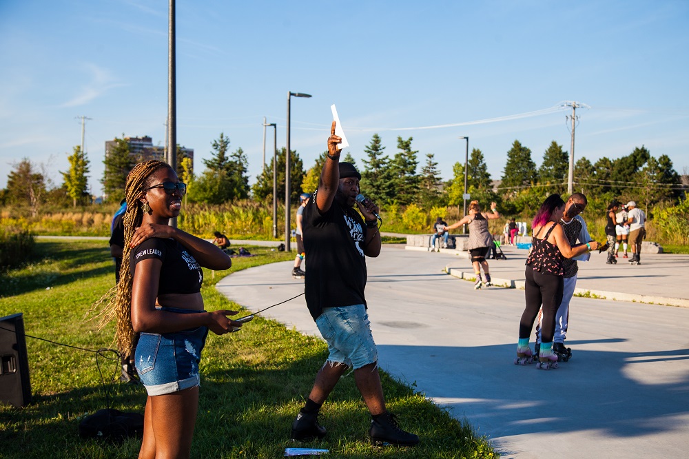 Two black people animating a roller skating event